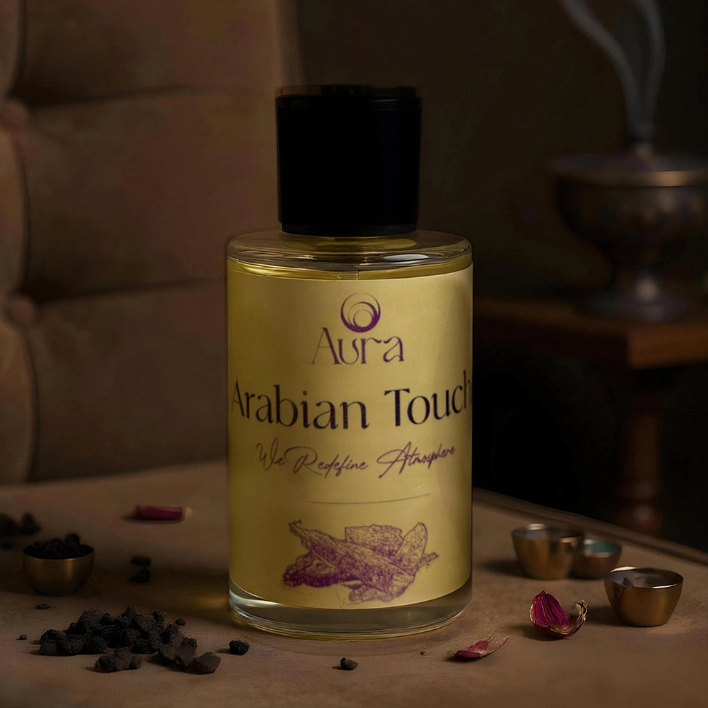 Bottle of Aura Arabian Touch essential oil on a wooden surface with decorative items.